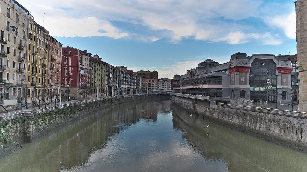 Bilbao 河流右侧的 Ribera 市场与左岸彩色建筑