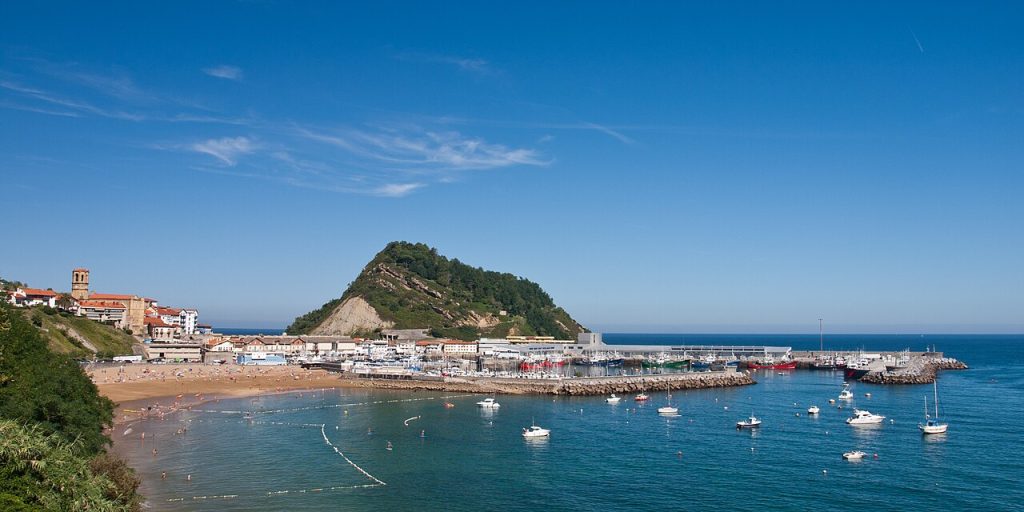 Getaria Malkorbe 海湾的沙滩、蓝色海水、港口与远处山丘