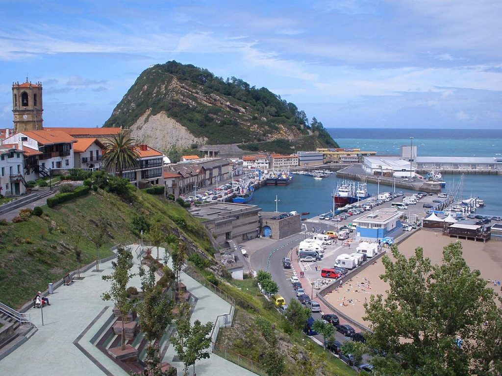 从上方看 Getaria 老城、港池、渔船与 San Antón 山